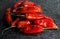 BRIGHT RED CHILIS ON A POLISHED BLACK MARBLE SURFACE