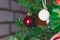 Bright red Christmas toys on the branches of an artificial Christmas tree. Snow balls and berries. A variety of festive accessorie