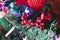 Bright red Christmas toys on the branches of an artificial Christmas tree. Snow balls and berries. A variety of festive accessorie