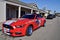 A bright red custom 2016 Mustang with red white and blue Horse decal on the side