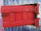 Bright red door with bolt. Rusty. Worn color plate. Caribbean style.  An old red metal material texture for your design