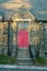 A Bright Red Door in a Cobblestone Church With Steps Leading Up to It