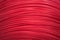 Bright red electric wire in large quantities. A coil of wire. abstraction, background, and texture