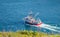 Bright red fishing boat heads out to sea from St. John\'s harbor Newfoundland, Canada.