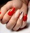 Bright red gel Polish with camouflage design and brushstrokes.