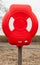 Bright red lifebuoy case on wooden pole