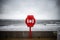 Bright red modern lifebuoy warning on storm sky ocean coastline. Life saving equipment preserver emergency station