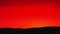 Bright red-orange sunrise behind the mountain