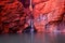 Bright red rocks of Handrail Pool in the Karijini National Park glowing in the sunlight