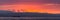 Bright red sunset sky over city and mountains