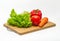 Bright red tomato, green salad, bell pepper, carrot on a board. Vegan food. Salad preparation