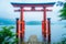 Bright red Torii gate submerged in the waters of Ashi lake, caldera with mountains on the background. Hakone Shrine