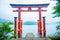 Bright red Torii gate submerged in the waters of Ashi lake, caldera with mountains on the background. Hakone Shrine, Kanagawa pref