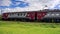 Bright red and white suburban electric train goes by on railway