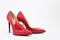 Bright red women`s stiletto heels. There are chili peppers nearby. Nice combination of shoes and pepper. Red color