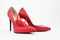 Bright red women`s stiletto heels. There are chili peppers nearby. Nice combination of shoes and pepper. Red color
