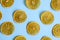 bright round sliced pieces of dried jerky oranges on a contrasting blue background, repeating pattern. flat lay, top view.