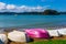Bright rowing boats upturned on an empty beach. Bay of Islands, New Zealand.