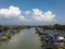 A bright scenery, blue sky, clouds, and a ship at the Ujung Negoro Beach pier in Central Java, Indonesia.