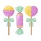 A bright set of three colorful candies of various shapes. Sweet heart-shaped lollipops, a round lollipop and a candy