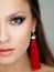Bright sexy makeup and red tassel earrings. Portrait of a brunette girl.