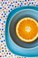 Bright sliced orange lies on blue plates. The composition is on a tablecloth