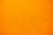 Bright solid color background. Empty orange surface with fine texture. Preparation for designer or layout