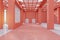 Bright spacious red industrial warehouse interior with city view and daylight.