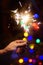 Bright sparkler with Christmas tree on background