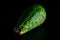 Bright spoiled avocado isolated on a black background, close-up. Violation of food storage conditions. unhealthy food with mold,