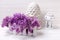 Bright spring lilac flowers in box and decorative lantern on wh