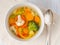 Bright spring vegetable soup with cauliflower, broccoli, pepper, carrot, green peas. Top view, white wooden background.