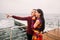 Bright stylish couple posing on berth and looking into the distance. Sea background. Wonderful honeymoon