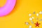 A bright summer background, seashells, a starfish and an inflatable pink circle in the corner. Bright yellow layout