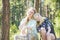 On a bright summer day  mom and daughter are joyful sitting on a log in the forest