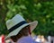 Bright sunhat on the head of an unidentifiable man, taken from behind, with blurred background bokeh