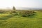 Bright sunlight begins to clear the mist over the Derbyshire autumn landscape