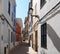 Bright sunlit narrow empty town street of picturesque old houses in Ciutadella menorca