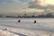 Bright sunny day, fishermen sitting on ice catch fish
