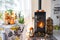 Bright sunny interior of the house with Black Metal Steel fireplace stove with fire and firewood with halloween decor and autumn