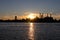 Bright Sunset and the Manhattan Skyline Silhouette with Smoke Stacks along the East River in New York City