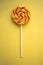Bright swirl lollipop on yellow background