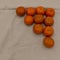 Bright tangerines are laid out in a triangle shape.
