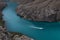 Bright turquoise blue mountain river Sulak with floating red speed boat with curved track on water, depth steep Sulak canyon slope