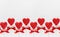 Bright valentine`s day background - sweet red lollipops hearts on white wood board as seamless border, layout for banner, header.