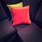 Bright velvet cushions on a dark sofa