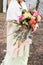 Bright wedding rustic bouquet in hand of bride