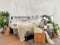 Bright white bedroom filled with numerous houseplants and flooded in natural light