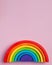 Bright wooden rainbow toy on a pink background, Montessori materials concept, early child development. Copy space.