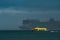 Bright yellow boat on front of a big cruise ship in stormy weather in the Western Caribbean